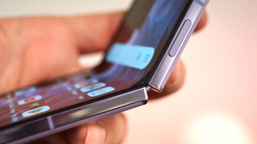 Шарнир на Oppo Find N2 Flip — крупный план частично сложенного в руке Oppo Find N2 Flip.