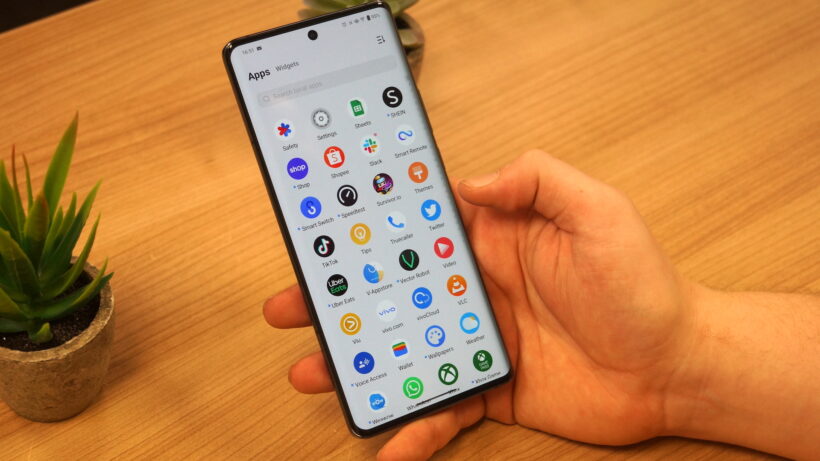 Смартфон Vivo X90 Pro с приложениями, отображаемыми на экране, в руке.