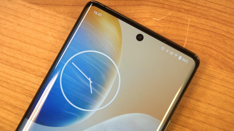 Смартфон Vivo X90 Pro с обоями в виде часов на экране.