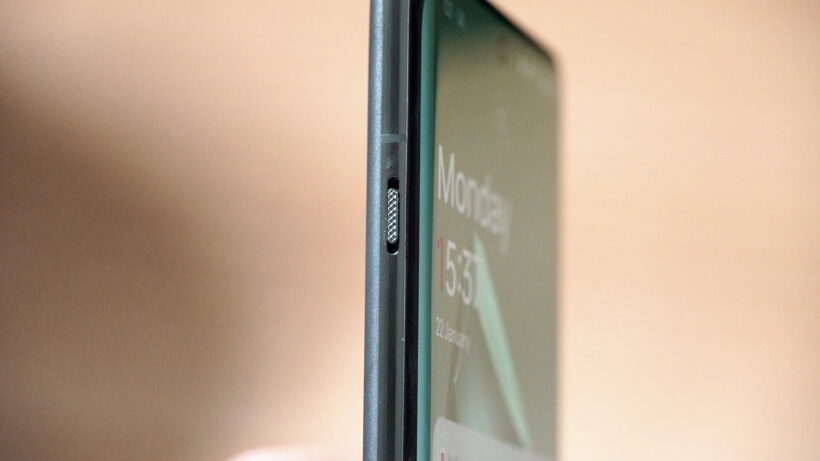 Ползунок уведомлений на OnePlus 12. Рука, держащая OnePlus 12 с открытым главным экраном и приложениями. Крупный план боково…