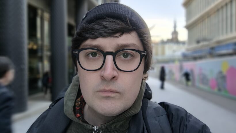 Селфи-камера Poco X6 Pro: мужчина в очках в фокусе на фоне размытого фона.