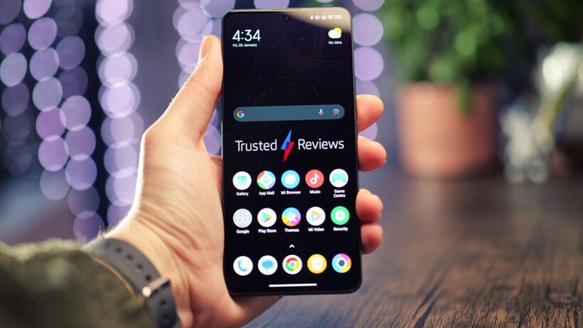 Poco X15 см — рука, держащая смартфон Poco X6 с отображаемыми на экране приложениями