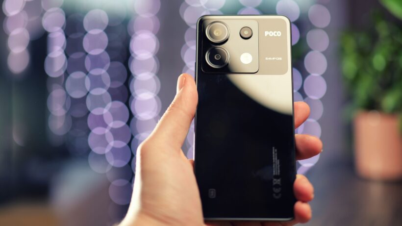 Задняя часть Poco X6. Рука, держащая смартфон Poco X6 с тройной камерой.