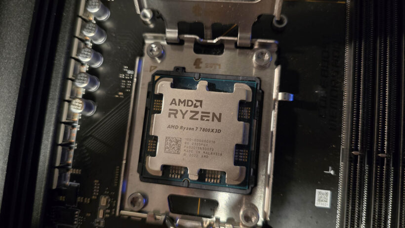 Процессор AMD Ryzen 7 7800X3D в разъеме процессора с поднятым фиксирующим кронштейном. Процессор AMD Ryzen 7 7800X3D, устано…