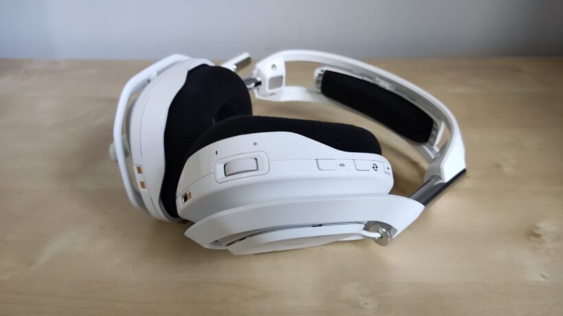 Astro A50 X лежит на боку, при этом одна чашка наушника согнута