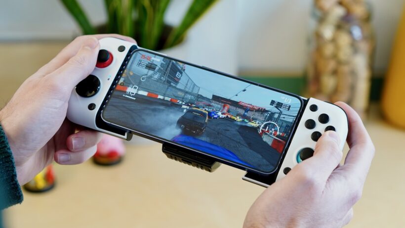 GameSir X8 см — руки, держащие контроллер GameSir X3, подключенный к смартфону, на котором запущена гоночная игра. Руки, дер…
