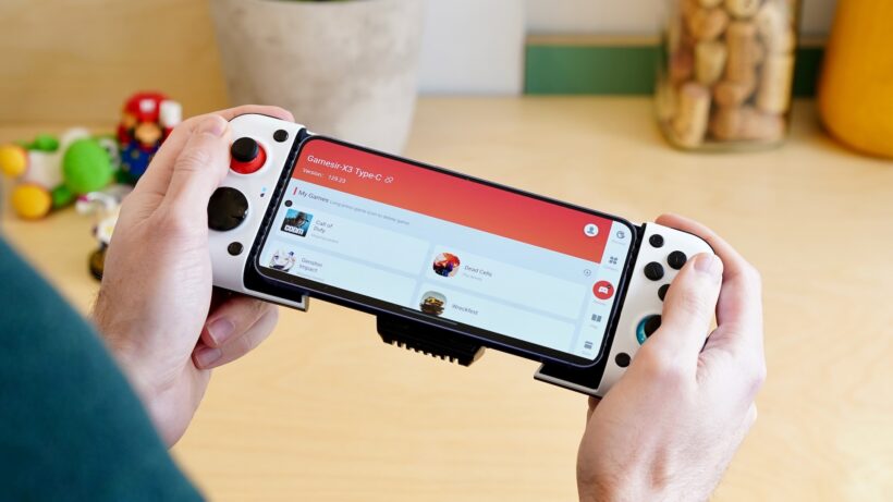 GameSir X3. Руки, держащие контроллер GameSir X3, подключенный к смартфону. Руки, держащие GameSir X3, подключенный к смартф…