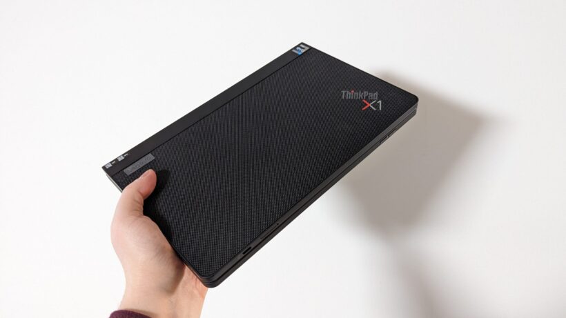 Lenovo ThinkPad X1 Fold в сложенном виде в руке. Рука держит Lenovo ThinkPad X1 Fold в сложенном состоянии.